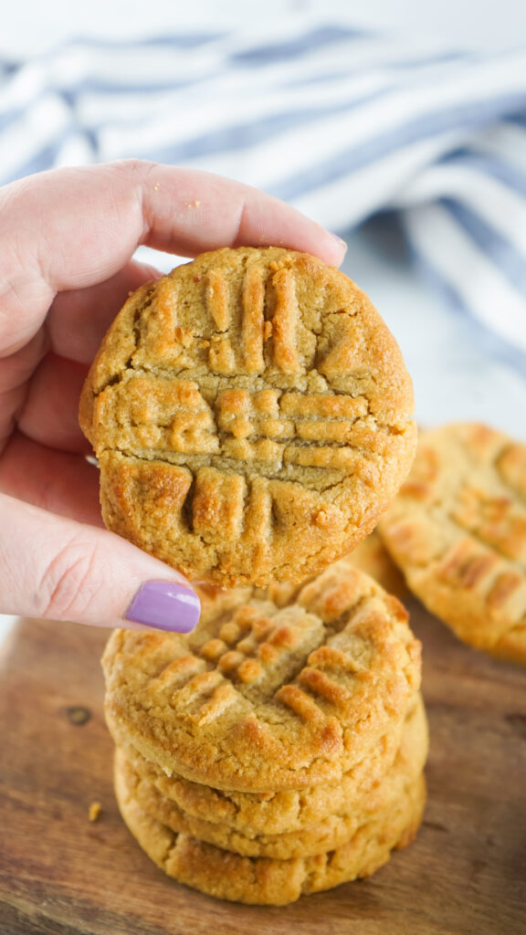 woman's hand holding an air fryer peanut butter cookie