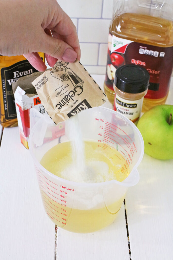 pouring unflavored gelatin into cider mixture