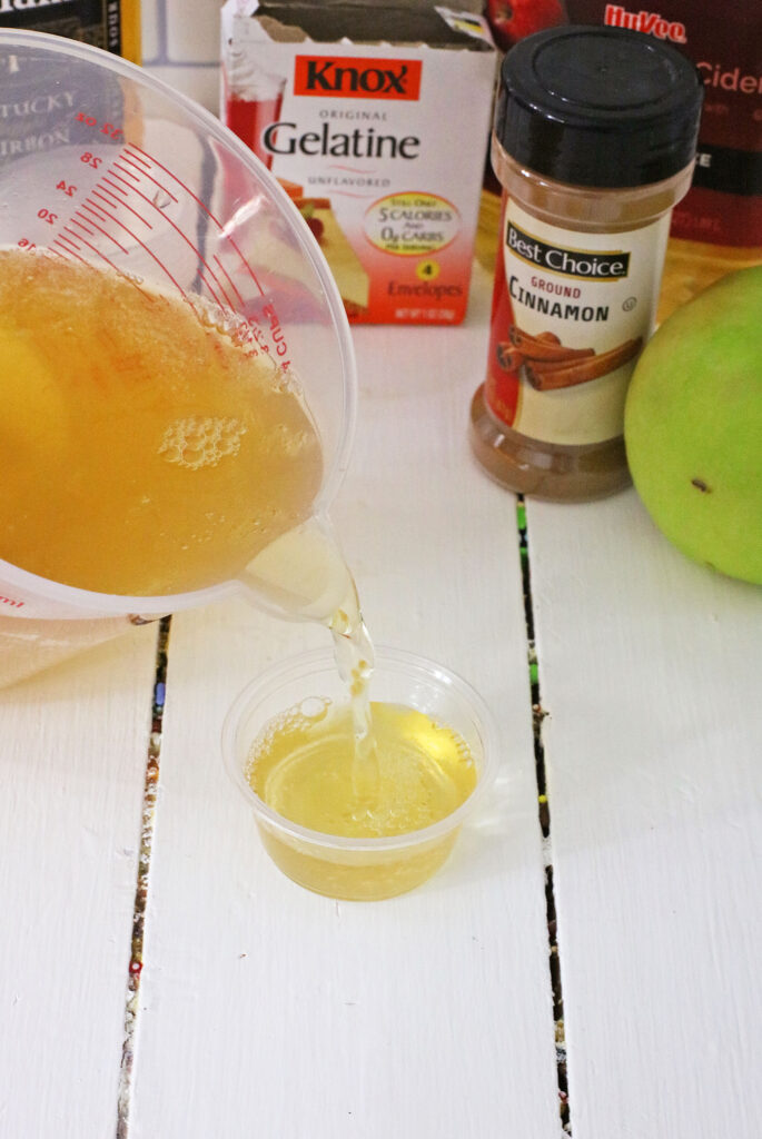 pouring jello shot mix into shot glasses