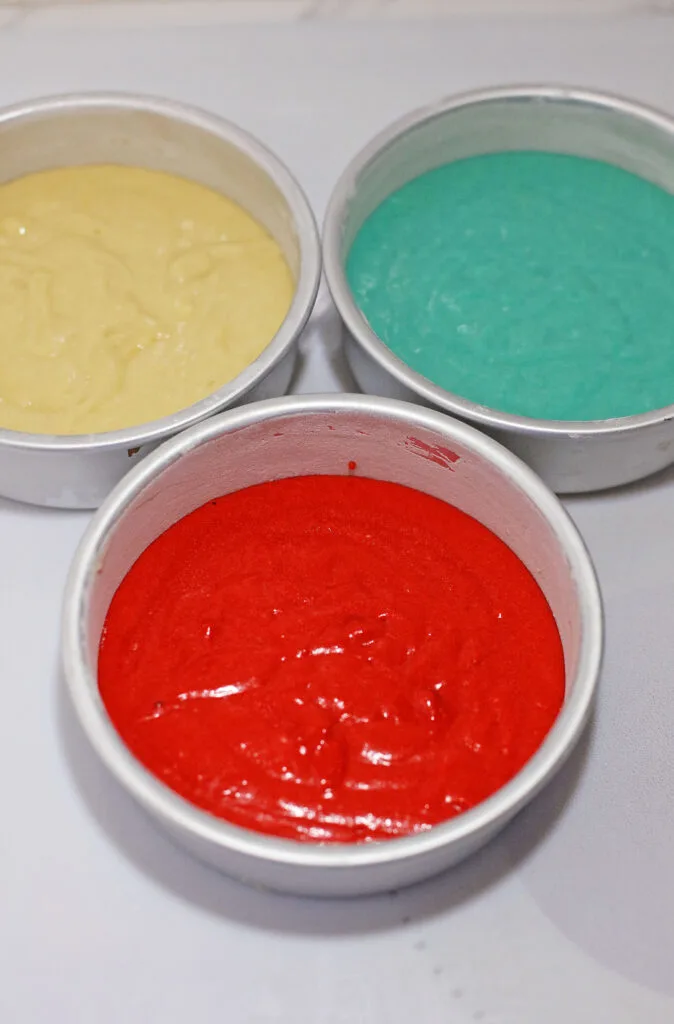 colored cake batter in cake pans